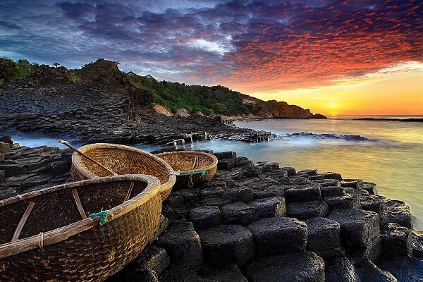 The sunrise with golden rays beautifully illuminates the dark rock formations